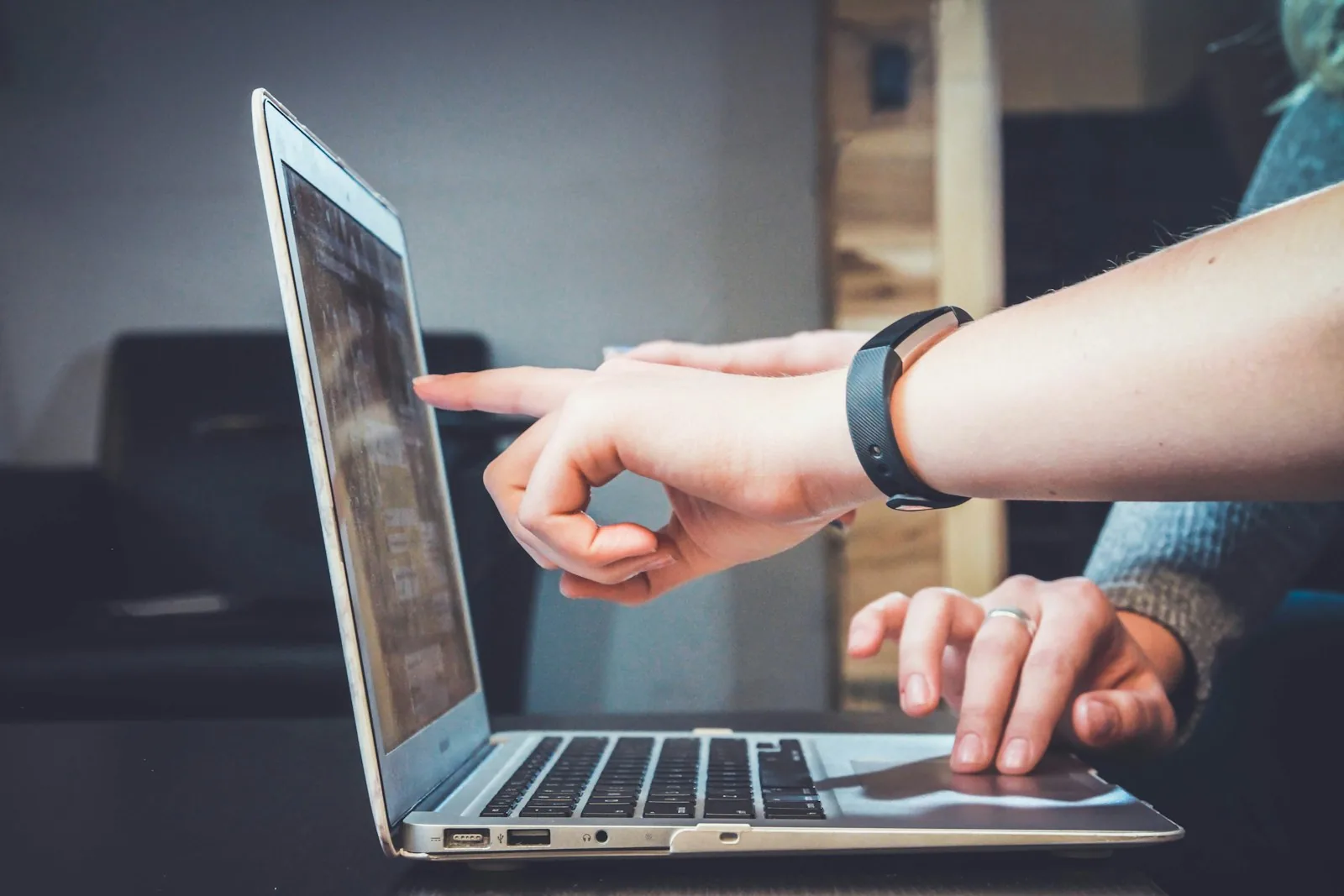 Hands reviewing a laptop together